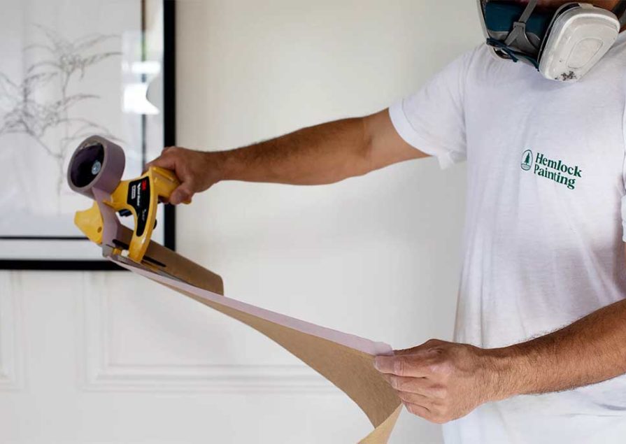 One of Hemlock's exterior painters prepares to protect surfaces before painting a home.