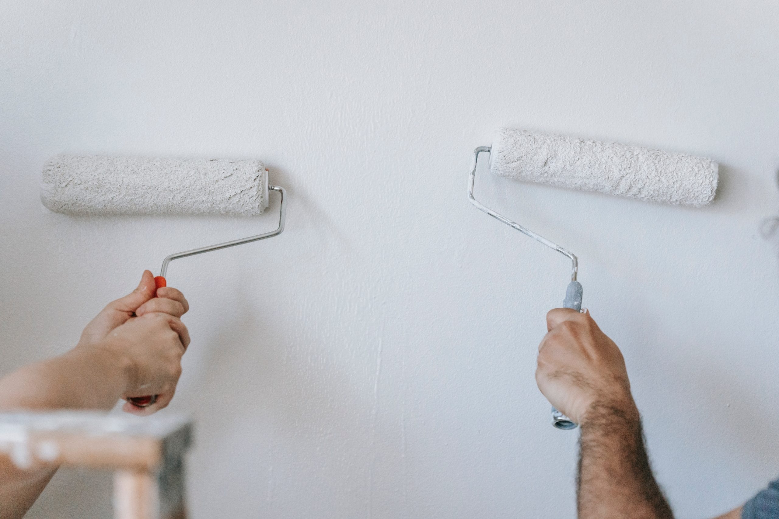 Two People Using a Paint Roller